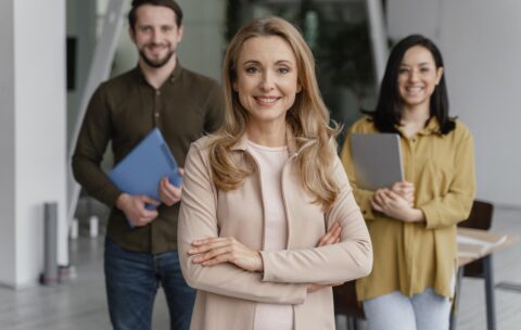 colegas-de-trabalho-sorridentes-posando-juntos-no-escritorio