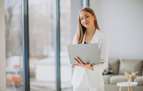 Young business woman in white suit working on a computer