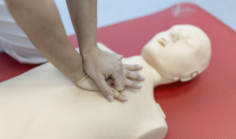 CPR class with instructors talking and demonstrating firt aid, compressions ans reanimation procedure. Cpr dummy