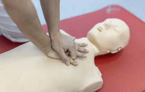 CPR class with instructors talking and demonstrating firt aid, compressions ans reanimation procedure. Cpr dummy