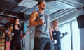 Group of people exercising with dumbbells in a fitness club or gym.