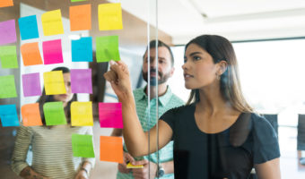 Colleagues Planning Over Adhesives With Team In Workplace