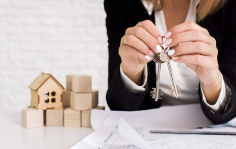 woman-holding-set-keys-with-wooden-cubes