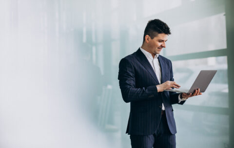Young handsome business man with laptop in office