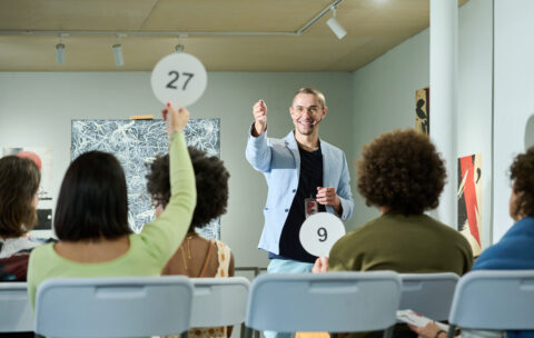 Pointing at one of female auctioneers