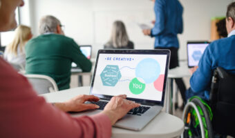 Rear view of senior people attending computer and technology education class.