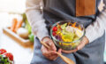 Closeup image of a female chef cooking and holding a bowl of fre