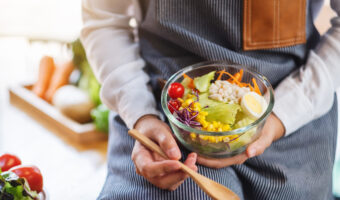 Closeup image of a female chef cooking and holding a bowl of fre