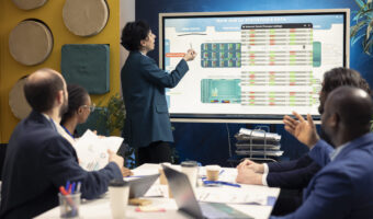 Business partners examining annual sales reports in corporate meeting