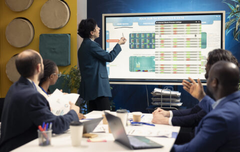 Business partners examining annual sales reports in corporate meeting