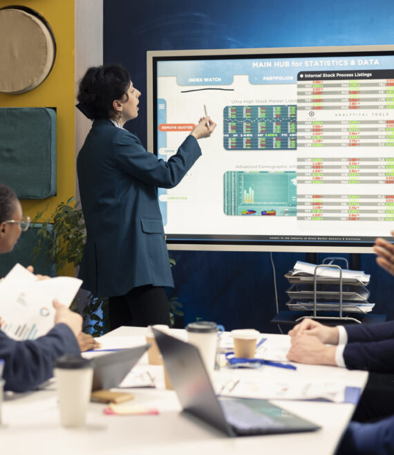 Business partners examining annual sales reports in corporate meeting