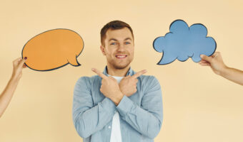 Tough choice between two ideas. Man standing in the studio with empty signs for the text