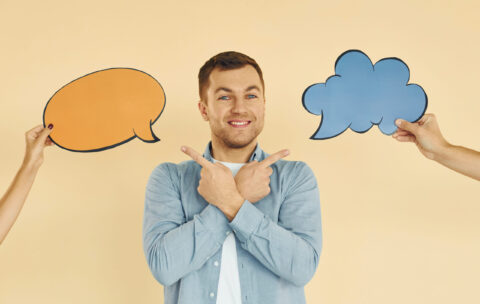 Tough choice between two ideas. Man standing in the studio with empty signs for the text