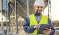 An industry worker using tablet for checking on supply in silos.