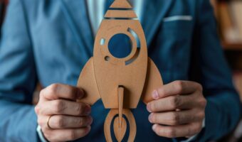 Businessman holding a rocket symbolizes startup and innovation for future success AIG59