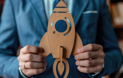 Businessman holding a rocket symbolizes startup and innovation for future success AIG59