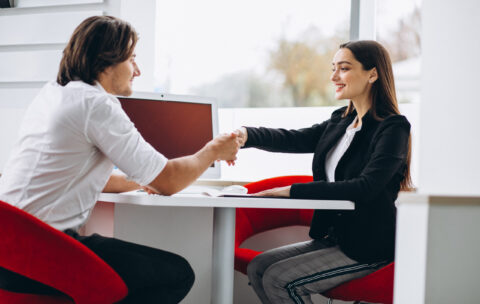Man talking with female sales person in a car show room