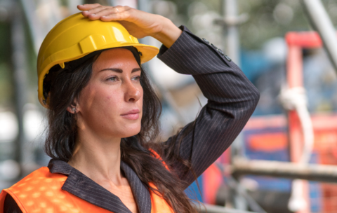 portrait-construction-worker-holding-fixing-her-safety-helmet AJUSTADA