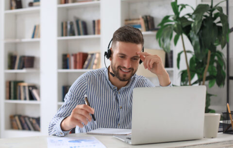 Smiling young business man having video call in office.