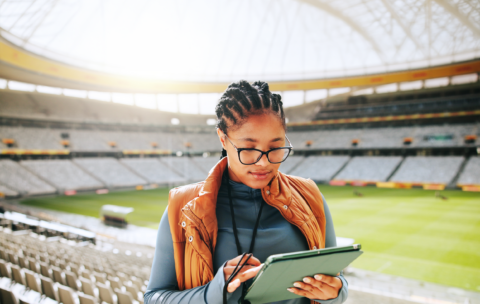 woman-coach-typing-with-tablet-stadium-sports-event-competition-review-tactics-african-person-tech-click-with-application-stats-decision-strategy-game-kenya